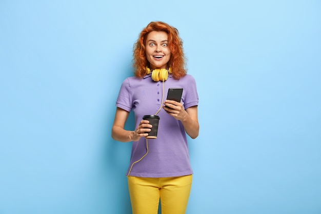 Photo of surprised cheerful woman has ginger hair