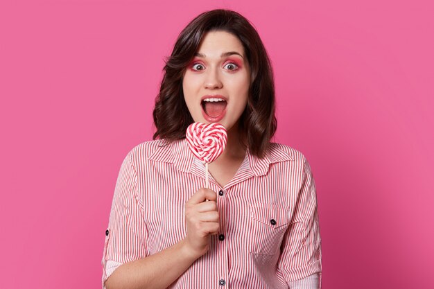 Photo of surprised European young woman with wide opened mouth