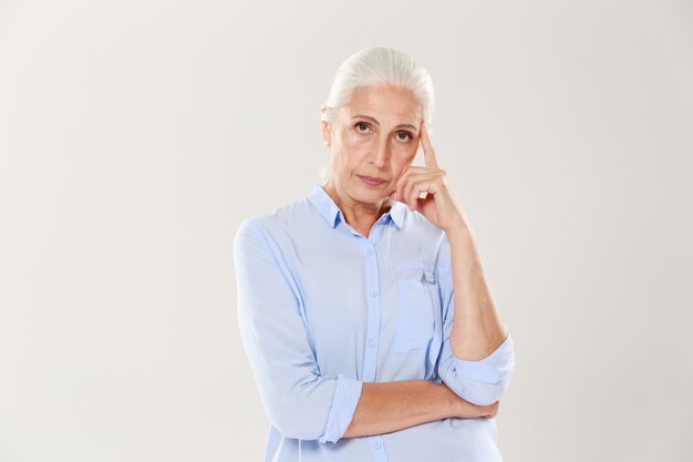 Photo of thinking old lady in blue shirt