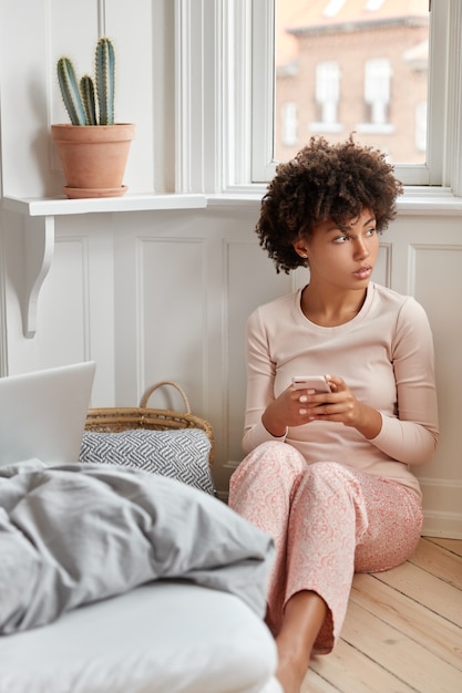 快適なナイトウェアを着た思いやりのある黒人の若い女性の写真