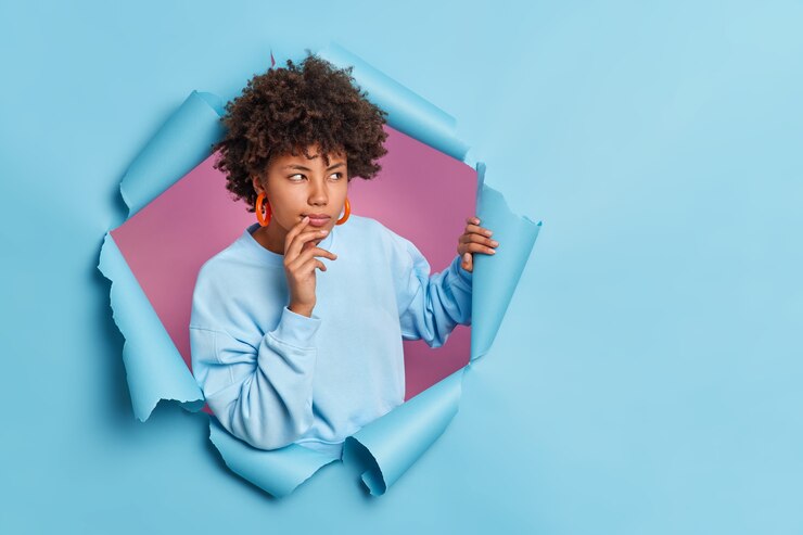 Free Photo photo of thoughtful dark skinned afro american woman looks away and considers something