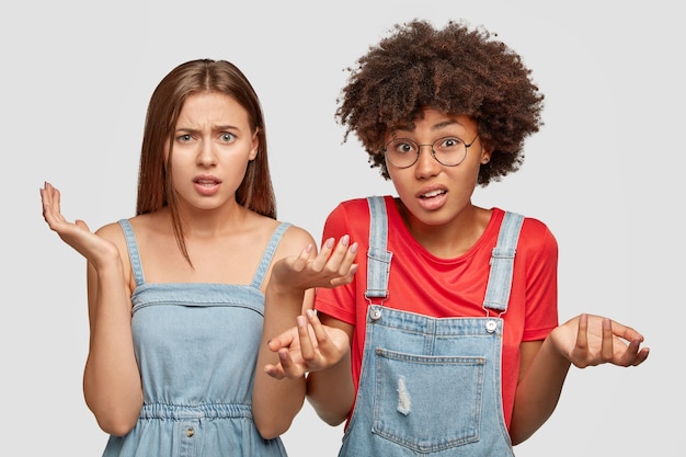 Free photo photo of uncertain girls of different races, express doubt