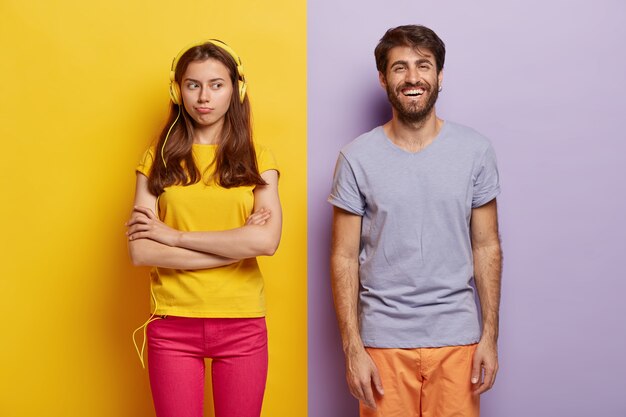 Photo of upset woman ignores husband, listens music in stereo headphones