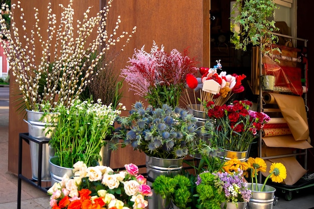 Photo of vases with coloured flowers in the street