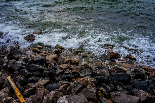 岩だらけの海岸を打つ水の写真