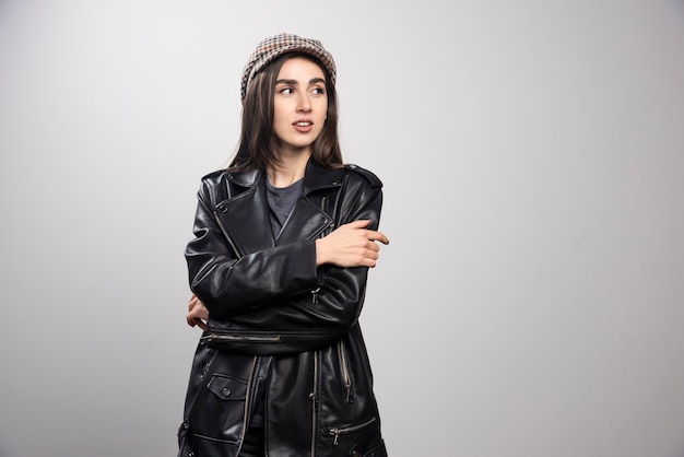 Free photo photo of a woman looking away in black leather jacket and cap.