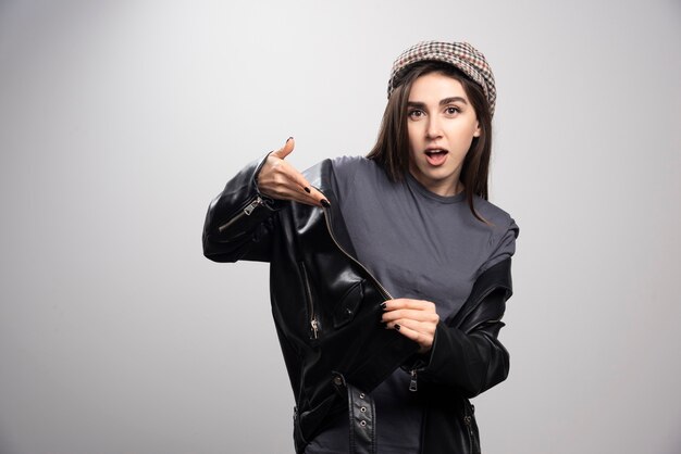 Photo of a woman wearing black leather jacket and cap.