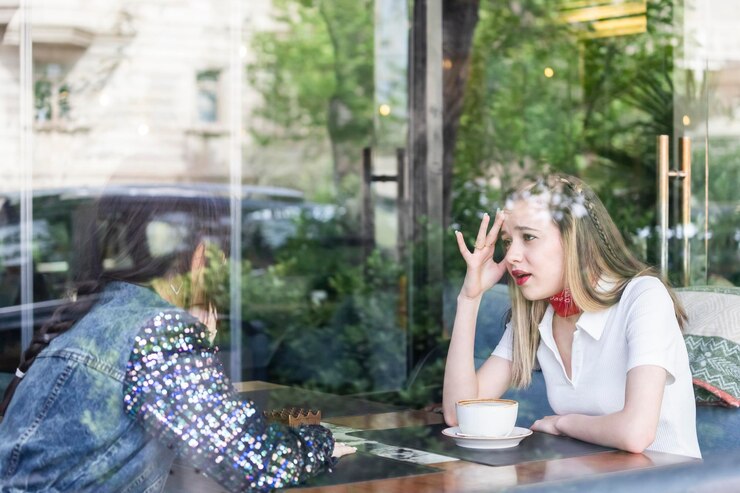 Free Photo photo of young beautiful lady sitting at the restaurant and talking with her friend