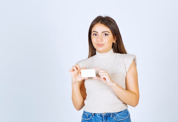 Photo of young beautiful woman model holding card and posing.