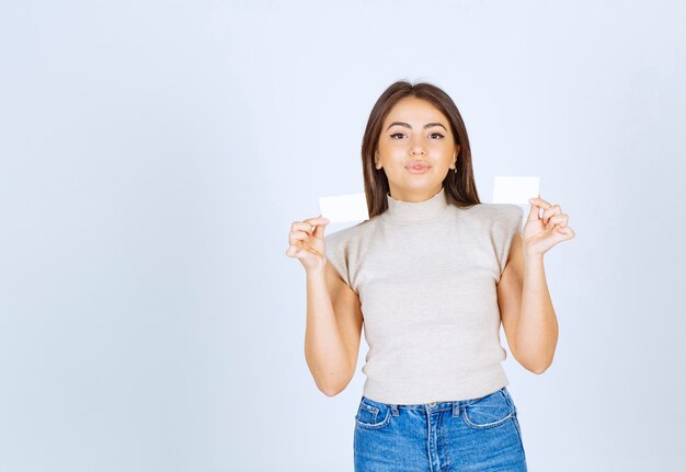 Photo of young beautiful woman model holding cards and posing.