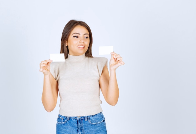 Photo of young beautiful woman model holding cards and posing.