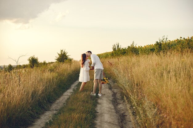 Photo of a young family walking at the field on a sunny day. 