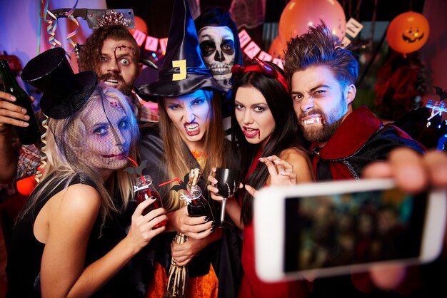 Фотография молодых друзей, веселых на вечеринке в честь Хэллоуина