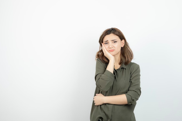 Photo of young girl having toothache over white wall. High quality photo