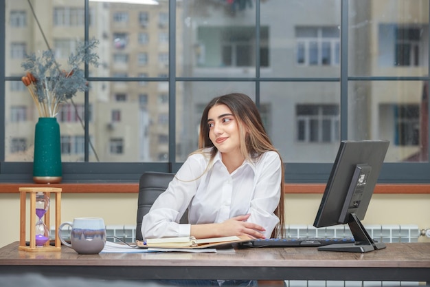 Free photo photo of a young girl sitting at the desk and smiling to the side