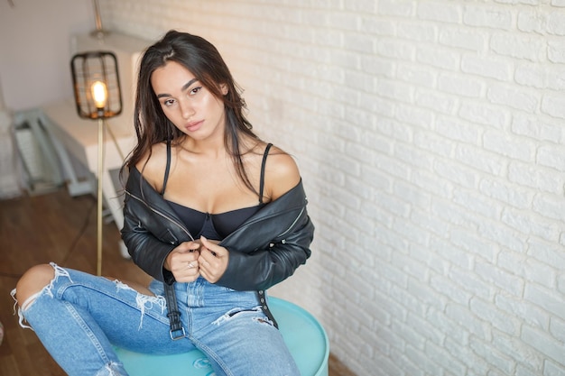 Photo of young hot girl at the room with black bra and blue jeans High quality photo
