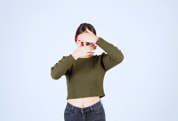 Foto gratuita foto di un modello di giovane donna adorabile che copre il viso con le mani