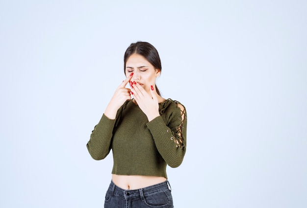 Free photo photo of a young nice woman model covering her mouth from cough .