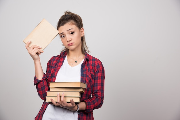 Photo of a young student holding a stack of books.