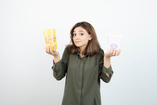 Photo of young woman in casual outfit holding popcorn. High quality photo