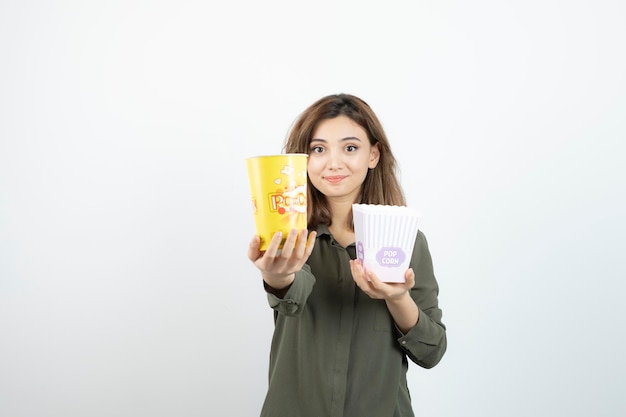 Photo of young woman in casual outfit holding popcorn. High quality photo