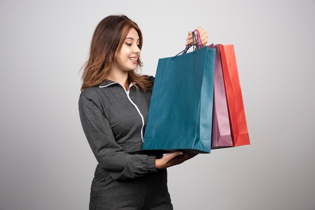 Photo of young woman holding shopping bags .