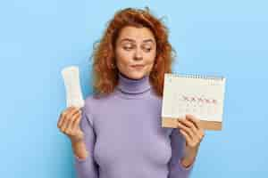 Free photo photo of young woman looks at period calendar, checks menstruation days