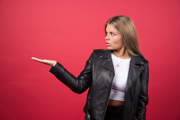 Photo of a young woman standing and showing copyspace