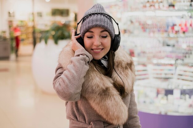 Photogenic женщина улыбается с heaphones в торговом центре0