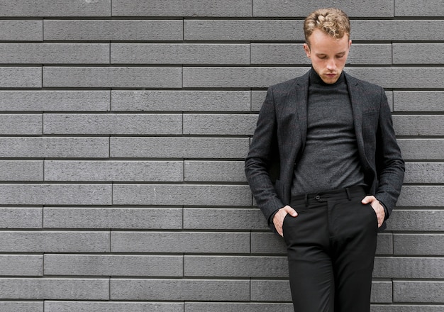 Photogenic young man leaning against the wall