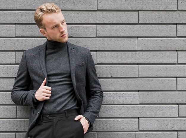 Photogenic young man near a gray wall