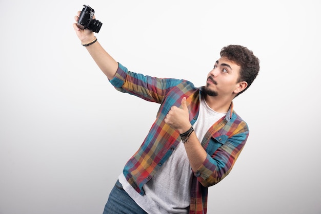 Foto gratuita fotografa scattando i suoi selfie in modo positivo con una macchina fotografica.