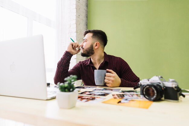 Photographer drinking coffee while at work