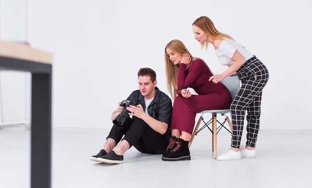 Photographer and models looking at the photos in studio