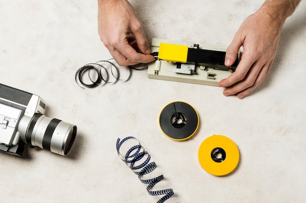 Photographer's hand cuts a film stipe on concrete backdrop