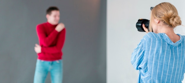 Photographer taking photos for man in red shirt