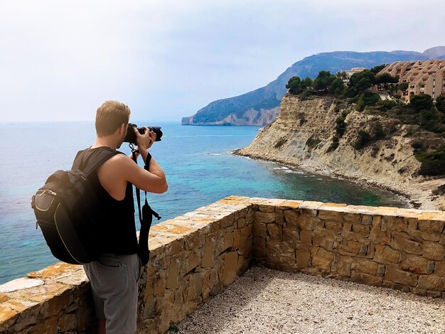 Photographer taking a picture of a ocean coast