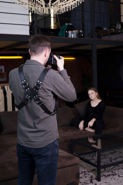 Photographer taking pictures of model on couch 