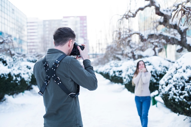 雪に覆われた通りでモデルの写真を撮る写真家