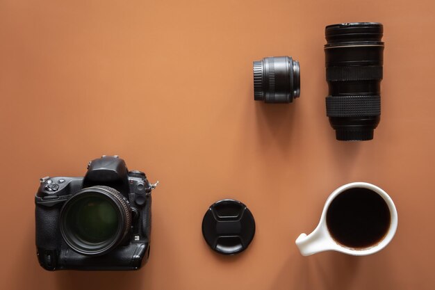 Photographers workplace with camera and lens flat lay