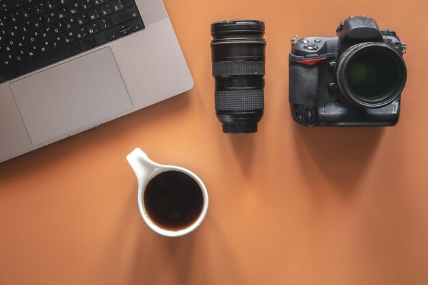 Photographers workplace with camera and lens flat lay