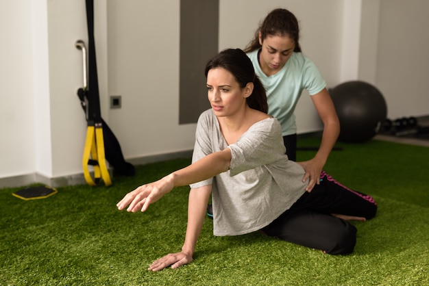 운동으로 젊은 백인 여자를 돕는 물리 치료사