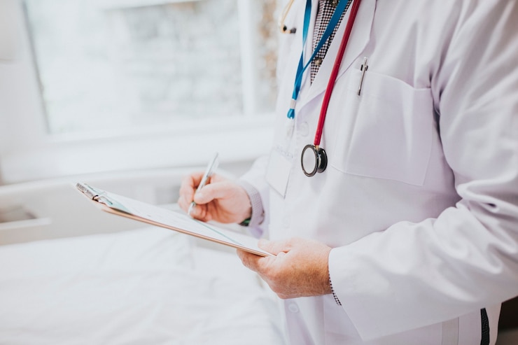 Free Photo physician noting down symptoms of a patient