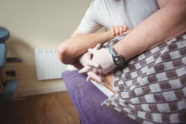 Free photo physiotherapist examining back of a patient