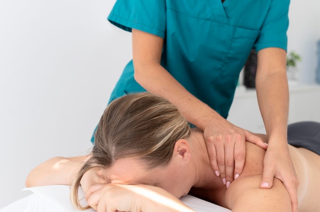 Free photo physiotherapist giving a massage to her patient at the clinic