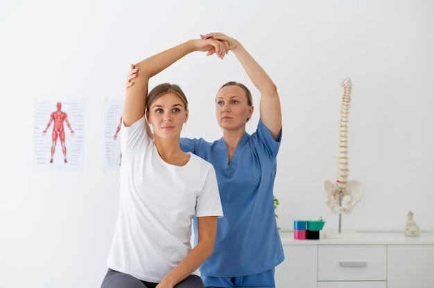 Physiotherapist helping a female patient at her clinic