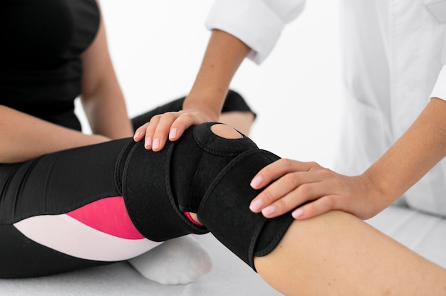 Free photo physiotherapist helping a female patient at her clinic