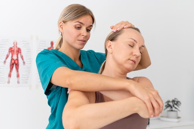 Physiotherapist helping a patient at her clinic