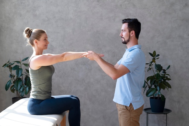 Free photo physiotherapist helping woman medium shot