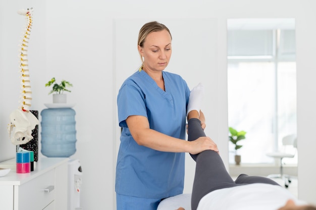 Free photo physiotherapist helping a young female patient